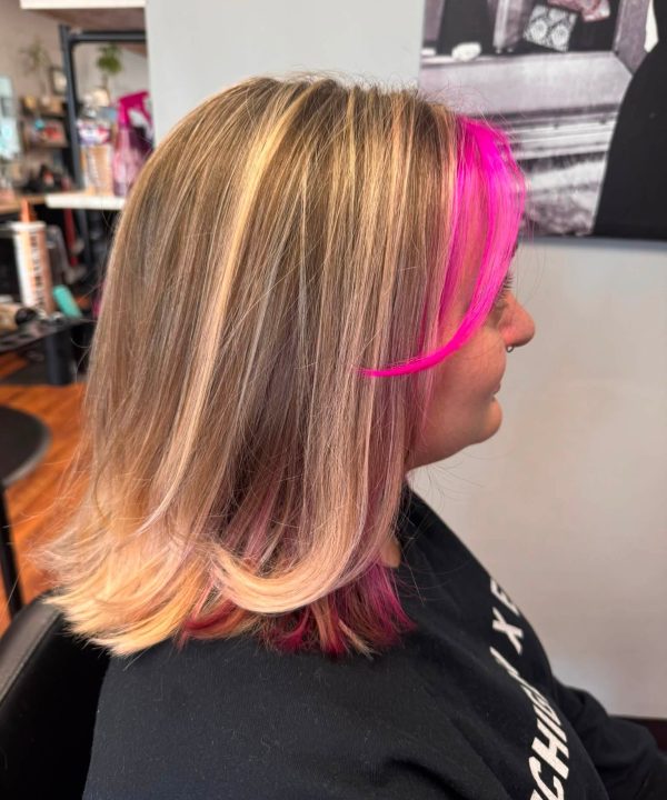 Bright pink face-framing highlights in a blonde bob