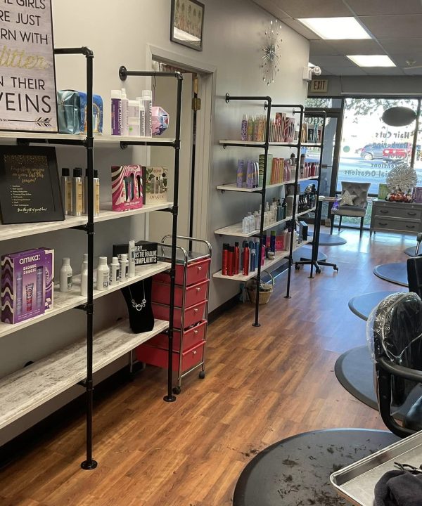 Salon interior with styling chairs, product shelves, and front windows