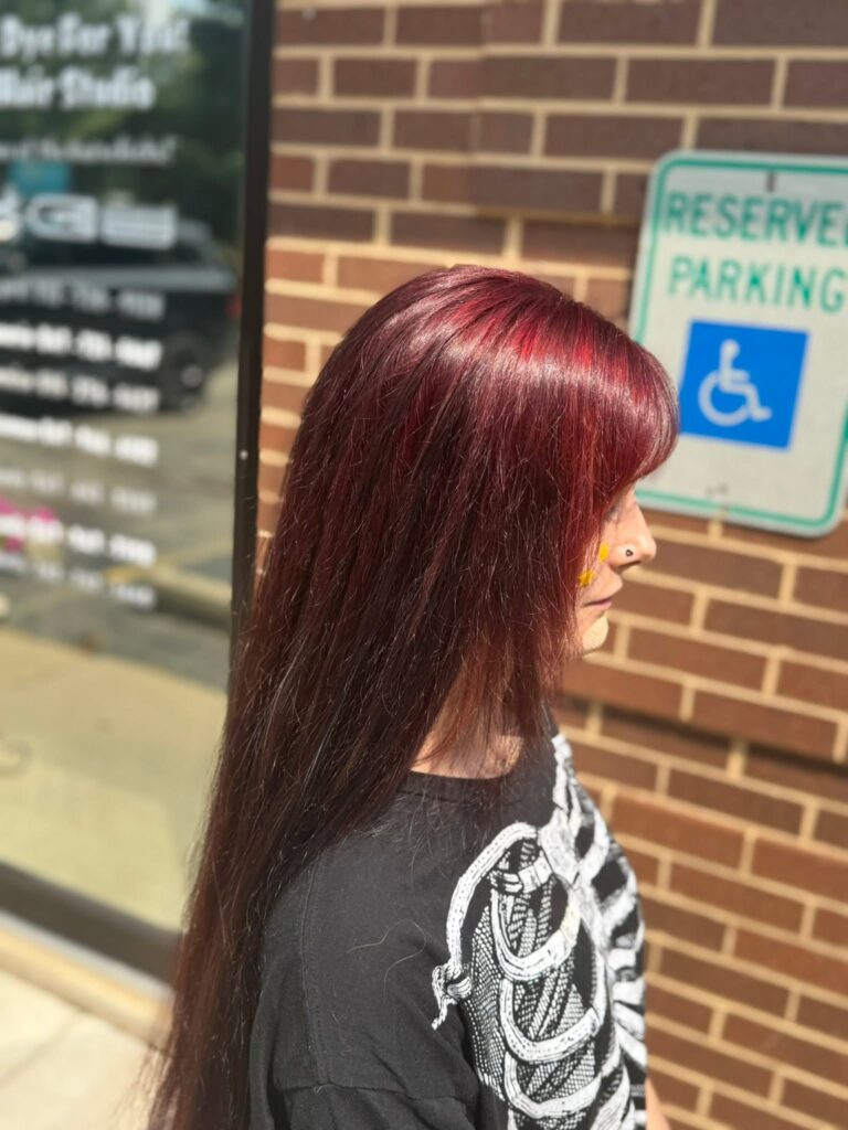 Long deep-red hair outside the studio