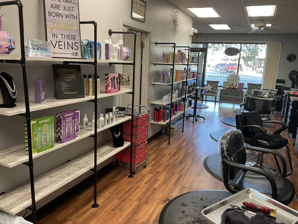 Salon interior with styling chairs, product shelves, and front windows